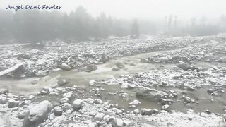 Angel Fowler Walks With Umbrella In Snow Next To River